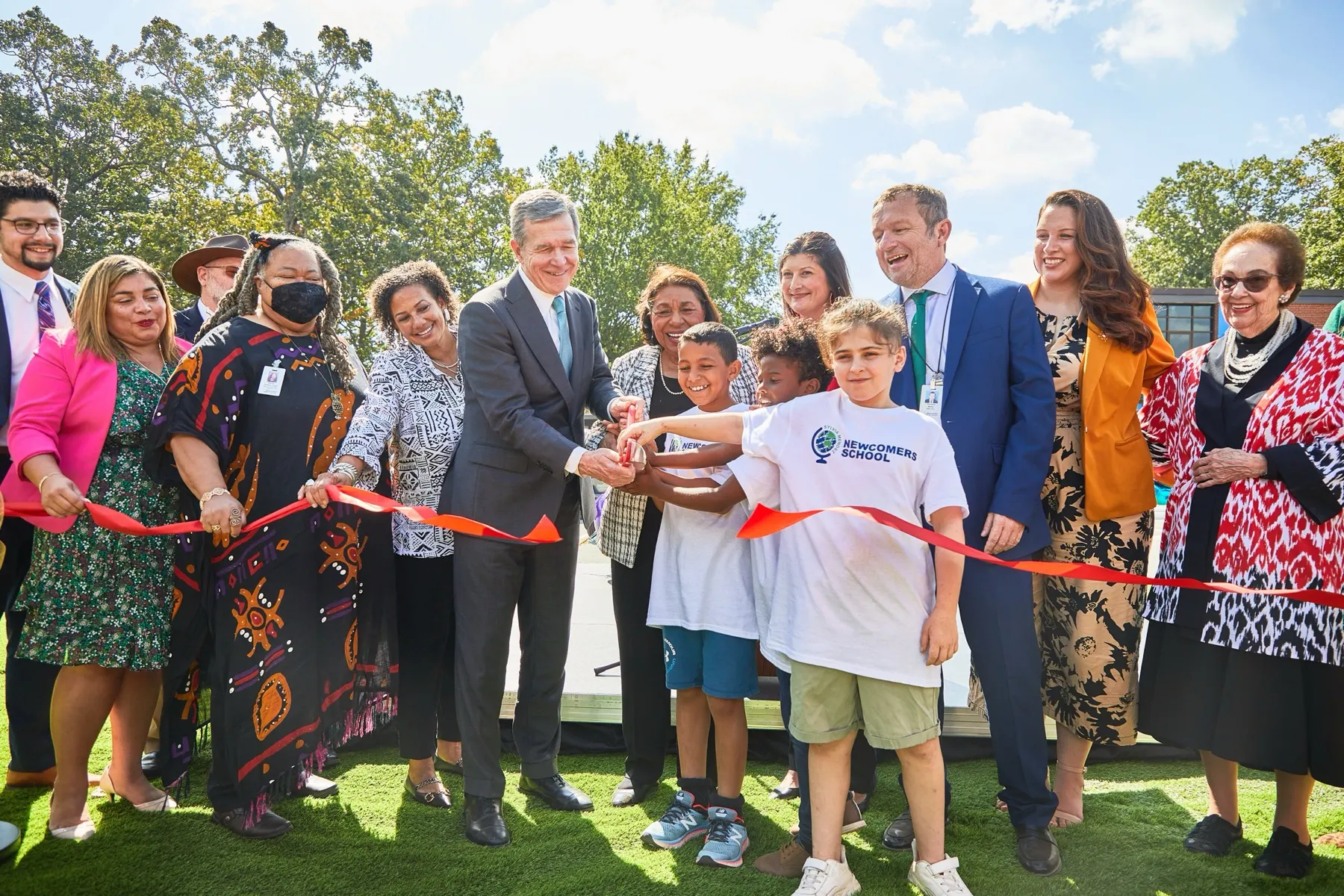 Students and North Carolina leaders cutting the ribbon at the Sylvia Mendez Newcomers School